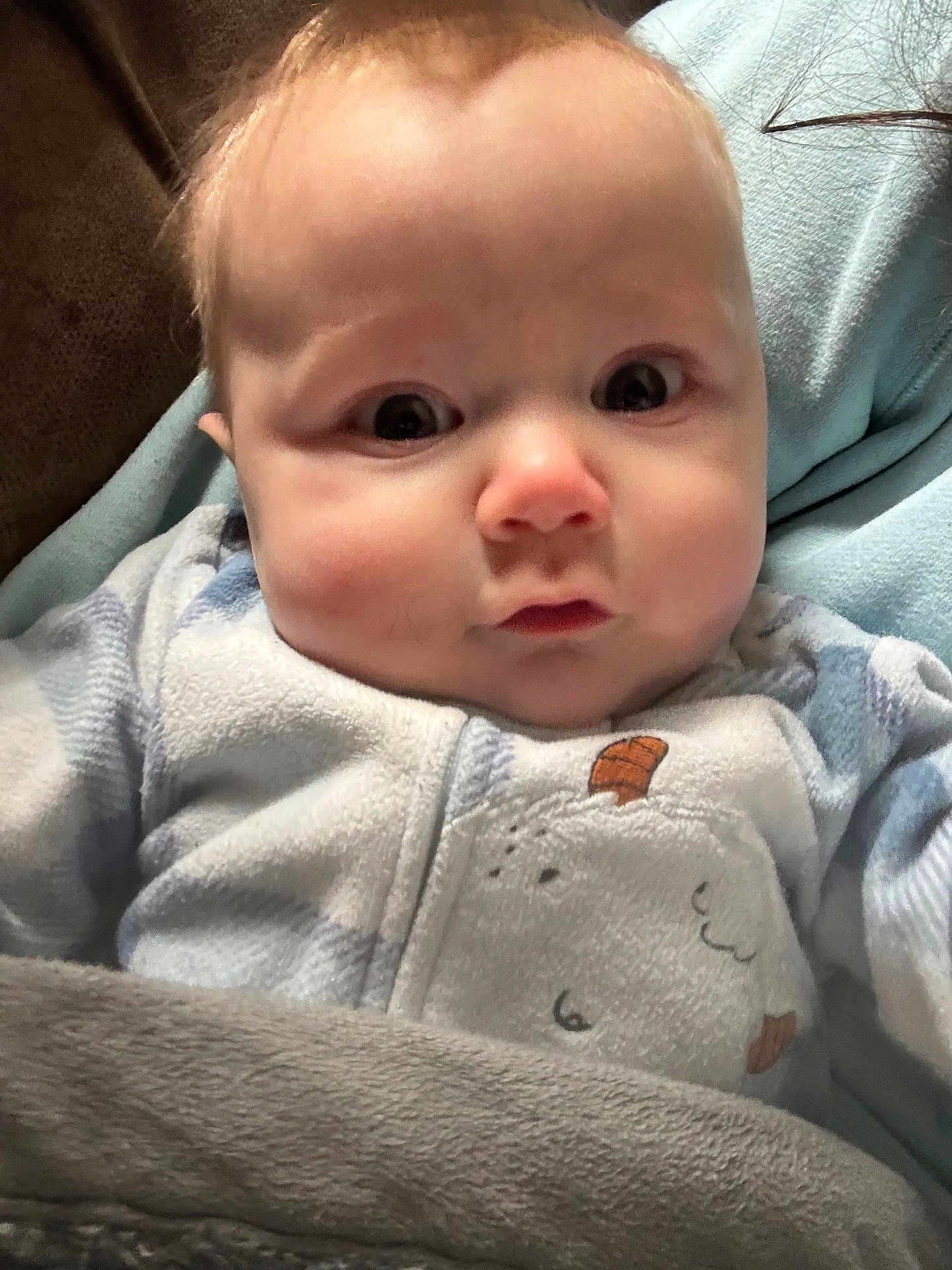 Vincent is registered to the contest to win money with this photo: baby, infant, face, onesie, blanket, soft_fabric, indoor, closeup, child, cute, expression, cozy, warm, person, portrait, newborn, clothing, sleepwear, young_child, resting