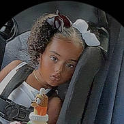 Yaya joined the competition — help win amazing prizes! child, toddler, car_seat, car, passenger, portrait, face, eyes, hair_bows, curly_hair, smiling, serious_expression, sippy_cup, baby_bottle, seatbelt, travel, indoors, vehicle, closeup, photograph