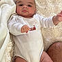 baby, infant, onesie, blanket, fluffy, soft, cute, person, child, skin, legs, arm, hand, face, lying_down, indoors, comfort, expression, reaching, animal_print