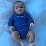 baby, infant, blue_onesie, plastic_sheet, outdoor, legs, arms, face, expression, skin, head, person, child, laying, feet, hands, casual, clothing, nature, curious