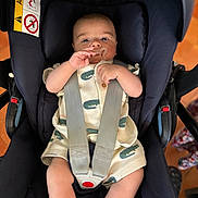 Loann participe au concours pour gagner de l'argent avec cette photo : baby, infant, car_seat, pacifier, straps, clothing, cute, indoors, child, person, seatbelt, sitting, looking, face, head, legs, hands, safety, comfort, car