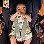 baby, infant, car_seat, pacifier, straps, clothing, cute, indoors, child, person, seatbelt, sitting, looking, face, head, legs, hands, safety, comfort, car
