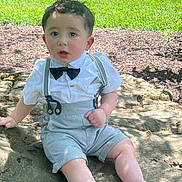 Oliver joined the competition — help win amazing prizes! toddler, child, boy, outdoor, grass, rock, sitting, clothing, white_shirt, bow_tie, suspenders, barefoot, face, curious, sunlight, nature, summer, portrait, cute, casual