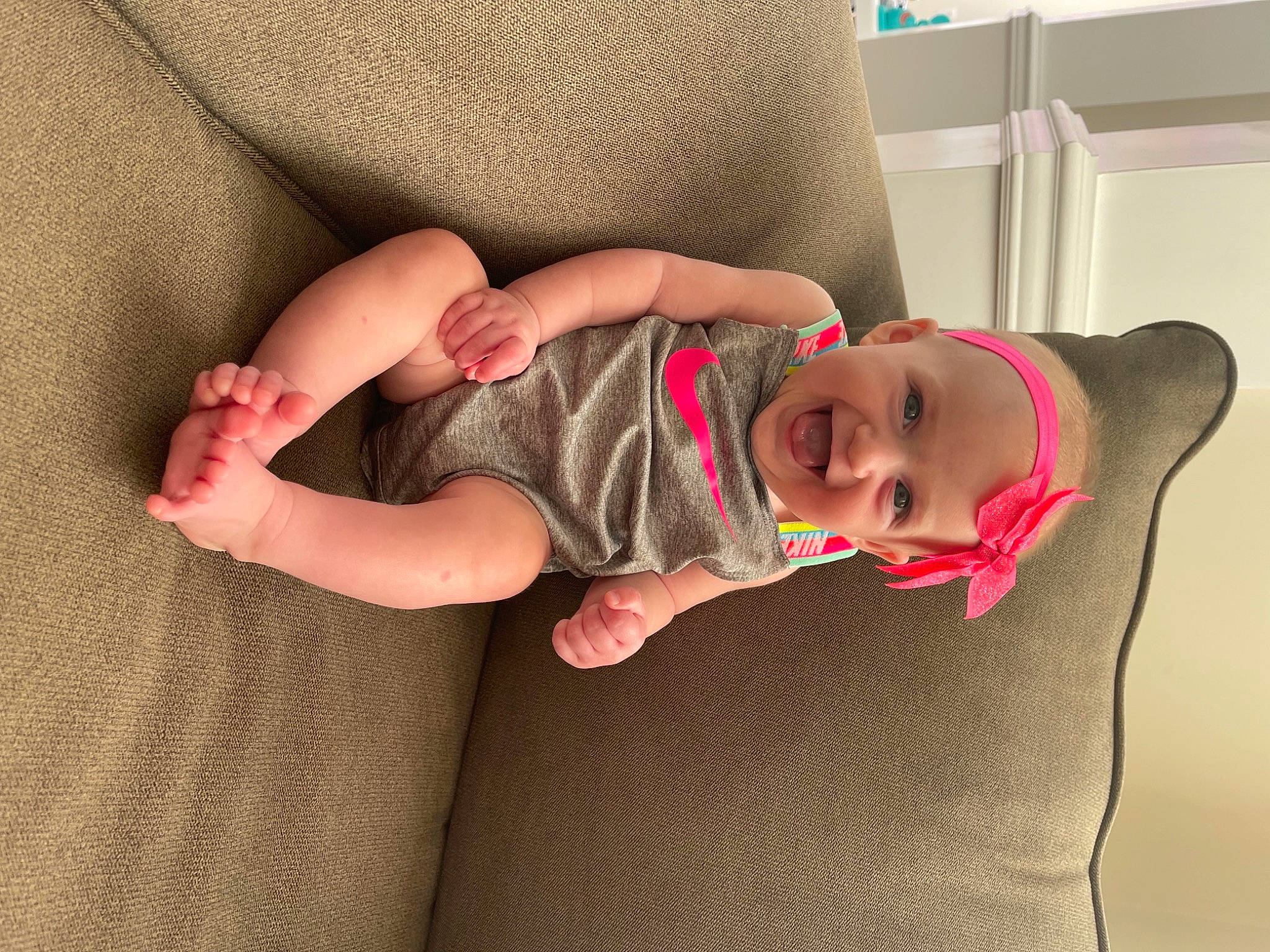Ava joined the competition — help win amazing prizes! arm, baby, baby_toddler_clothing, comfort, couch, eye, finger, glasses, headgear, headwear, human_body, joint, knee, mouth, person, pink, shoulder, skin, sleeve, smile