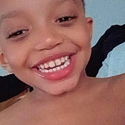 King is registered to the contest to win money with this photo: child, smiling, face, teeth, skin, head, indoors, portrait, happy, person, bare_shoulders, closeup, young, joy, expression, casual, human, cute, childhood, selfie