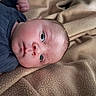 Colby is registered to the contest to win money with this photo: baby, infant, face, blanket, blue_clothing, newborn, skin, head, portrait, lying_down, soft_texture, indoors, closeup, young_child, peaceful, child, cute, sleepwear, resting, human