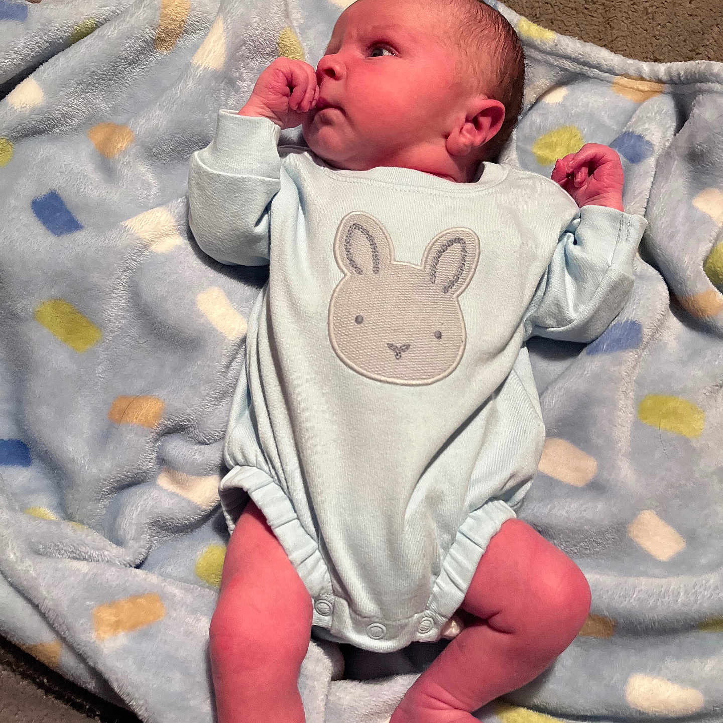 Colby is registered to the contest to win money with this photo: newborn, baby, infant, blanket, onesie, cute, soft, lying, clothing, indoors, person, child, face, head, skin, legs, hand, foot, expression, bunny