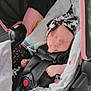 Josie is registered to the contest to win money with this photo: baby, infant, car_seat, sleeping, headband, blanket, clothing, child, seatbelt, safety, cute, indoor, rest, newborn, comfort, soft_lighting, pink, black, white, pattern