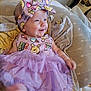 baby, smiling, headband, dress, purple, cartoon_print, cushion, blanket, indoor, infant, happy, person, foot, furniture, guitar, wooden_wall, patterned_clothing, tutu, cute, child