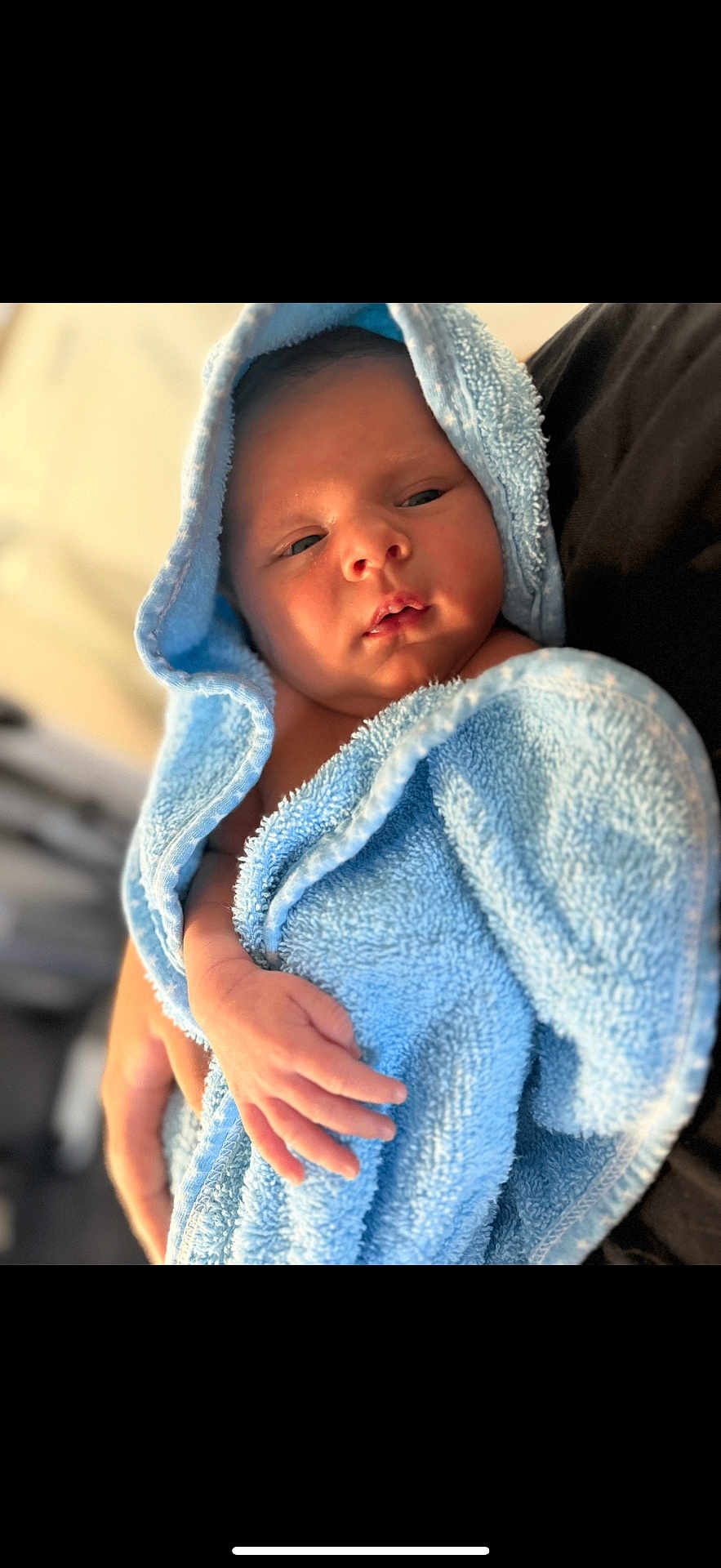 Ronnie joined the competition — help win amazing prizes! newborn, baby, towel, blue_towel, hooded_towel, infant, hand, skin, portrait, person, soft_texture, warm_lighting, closeup, cradling, resting, indoors, gentle, peaceful, child, cute