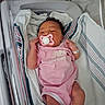 Aaliyah is registered to the contest to win money with this photo: newborn, baby, infant, hospital, bassinet, pacifier, pink_clothing, romper, blanket, swaddle, face, hair, hands, legs, sleeping, awake, portrait, medical_wristband, crib, new_balance