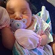 Aaliyah joined the competition — help win amazing prizes! newborn, baby, sleeping, pacifier, blanket, mitten, infant, portrait, close_up, face, eyes_closed, colorful, clothing, swaddled, cozy, indoors, soft_lighting, resting, nursery, photography