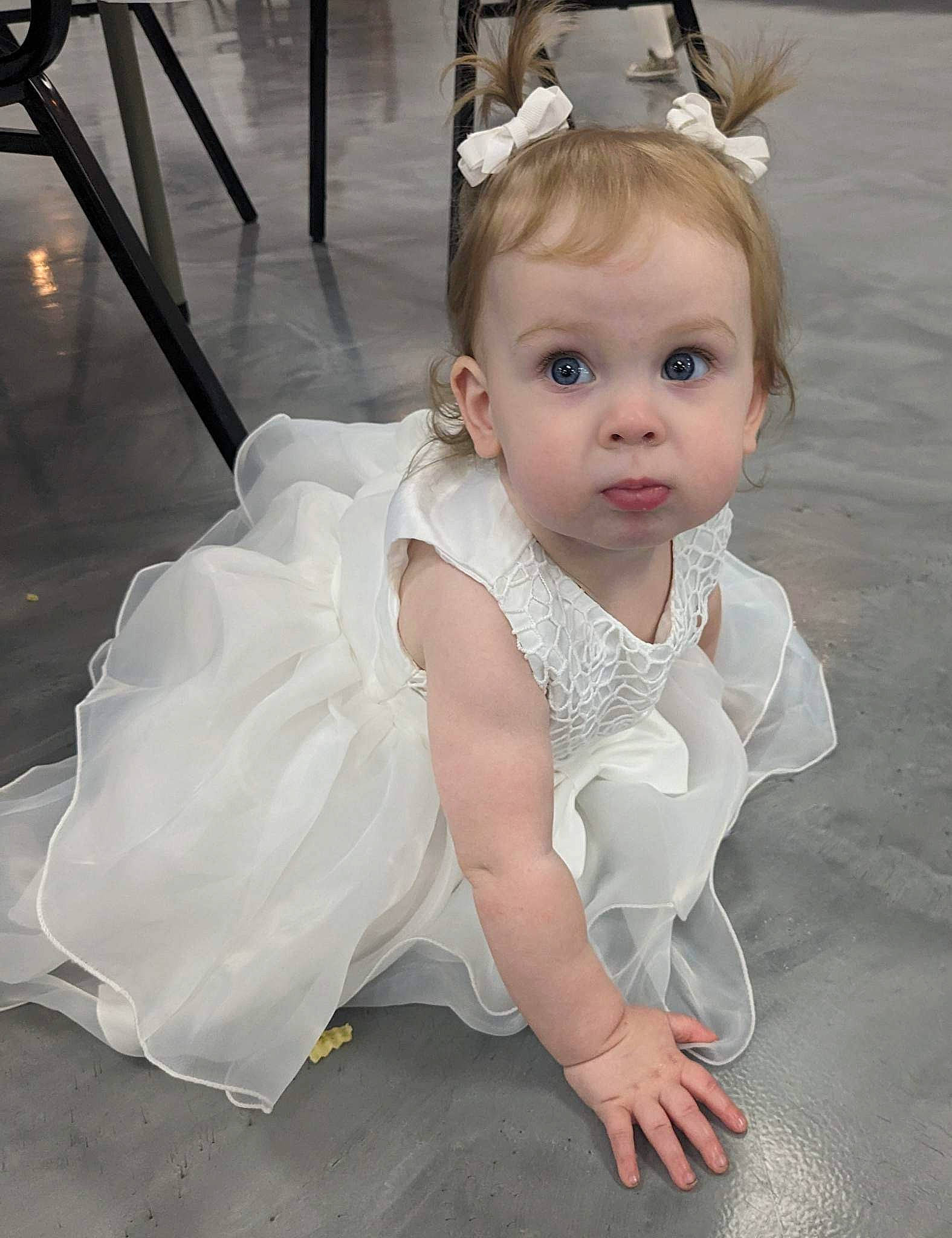 Emery is registered to the contest to win money with this photo: baby, baby_toddler_clothing, bridal_accessory, bridal_clothing, dress, embellishment, eyebrow, eyelash, floor, flooring, gown, hair_accessory, happy, headgear, headpiece, iris, long_hair, person, skin, surprise