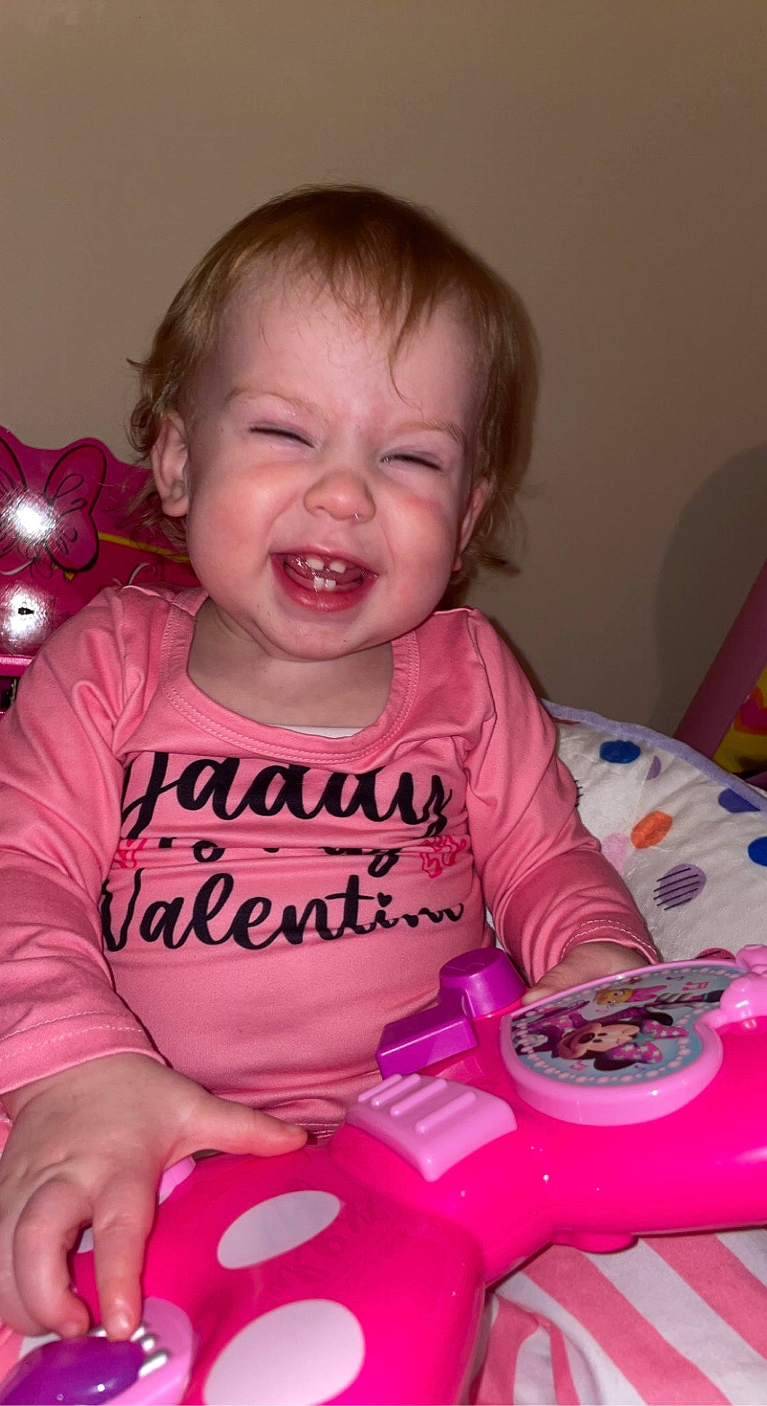 Emery is registered to the contest to win money with this photo: arm, baby, baby_playing_with_toys, baby_toddler_clothing, cheek, child, facial_expression, finger, fun, happy, iris, lip, mouth, nose, person, pink, product, skin, sleeve, smile