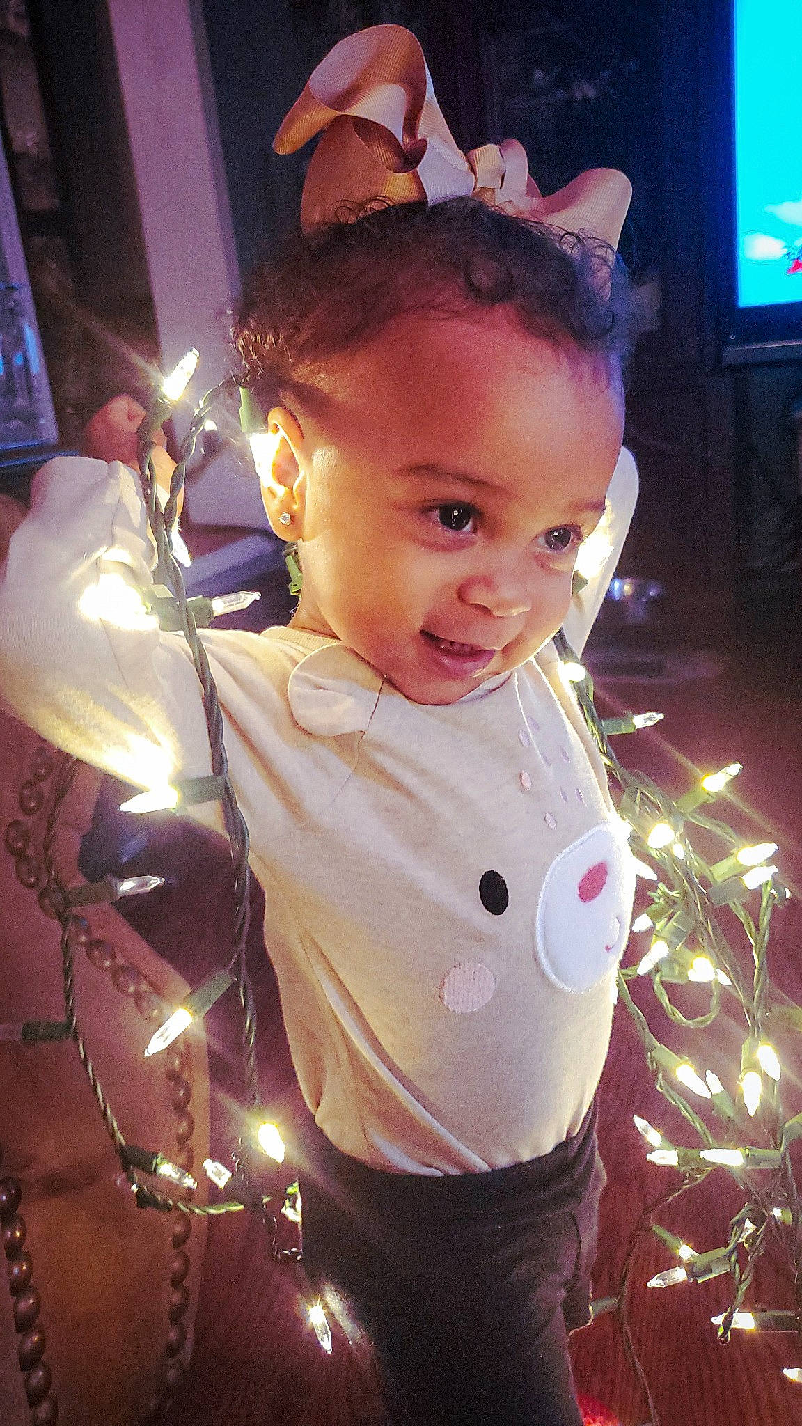 Nova Daniela is registered to the contest to win money with this photo: child, christmas, christmas_decoration, christmas_eve, christmas_ornament, event, eye, facial_expression, fun, happy, head, holiday, light, ornament, person, pink, purple, television, toddler, tradition