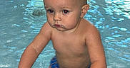 Carter is registered to the contest to win money with this photo: baby, blond, blue_swimsuit, child, edge, face, floor, greenery, grip, hands, indoor, pool, portrait, reflection, skin, swimming, toddler, water, wet, window