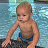 Carter is registered to the contest to win money with this photo: toddler, child, pool, water, indoor, swimming, baby, skin, hands, face, blond, blue_swimsuit, wet, edge, grip, reflection, window, greenery, floor, portrait