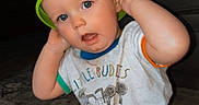 Carter is registered to the contest to win money with this photo: toddler, child, bucket, green_bucket, hat, indoor, carpet, living_room, mickey_mouse, tshirt, diaper, kneeling, cute, blue_eyes, playful, baby, person, clothing, floor, expression