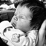 Charlotte joined the competition — help win amazing prizes! baby, sleeping, infant, newborn, onesie, bear_print, soft_hair, face, person, hand, cradling, black_and_white, closeup, cozy, peaceful, portrait, cute, tender, gentle, indoor