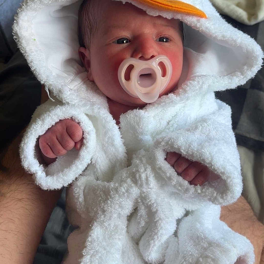 Delilah joined the competition — help win amazing prizes! baby, blanket, bonnet, clothing, face, hat, head, hood, newborn, person, photography, portrait, quilt, towel, yawning
