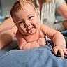 Anne joined the competition — help win amazing prizes! adult, arm, baby, bed, blanket, blurred_background, child, closeup, cute, expression, hand, happy, indoors, infant, person, playful, portrait, skin, smiling, tongue