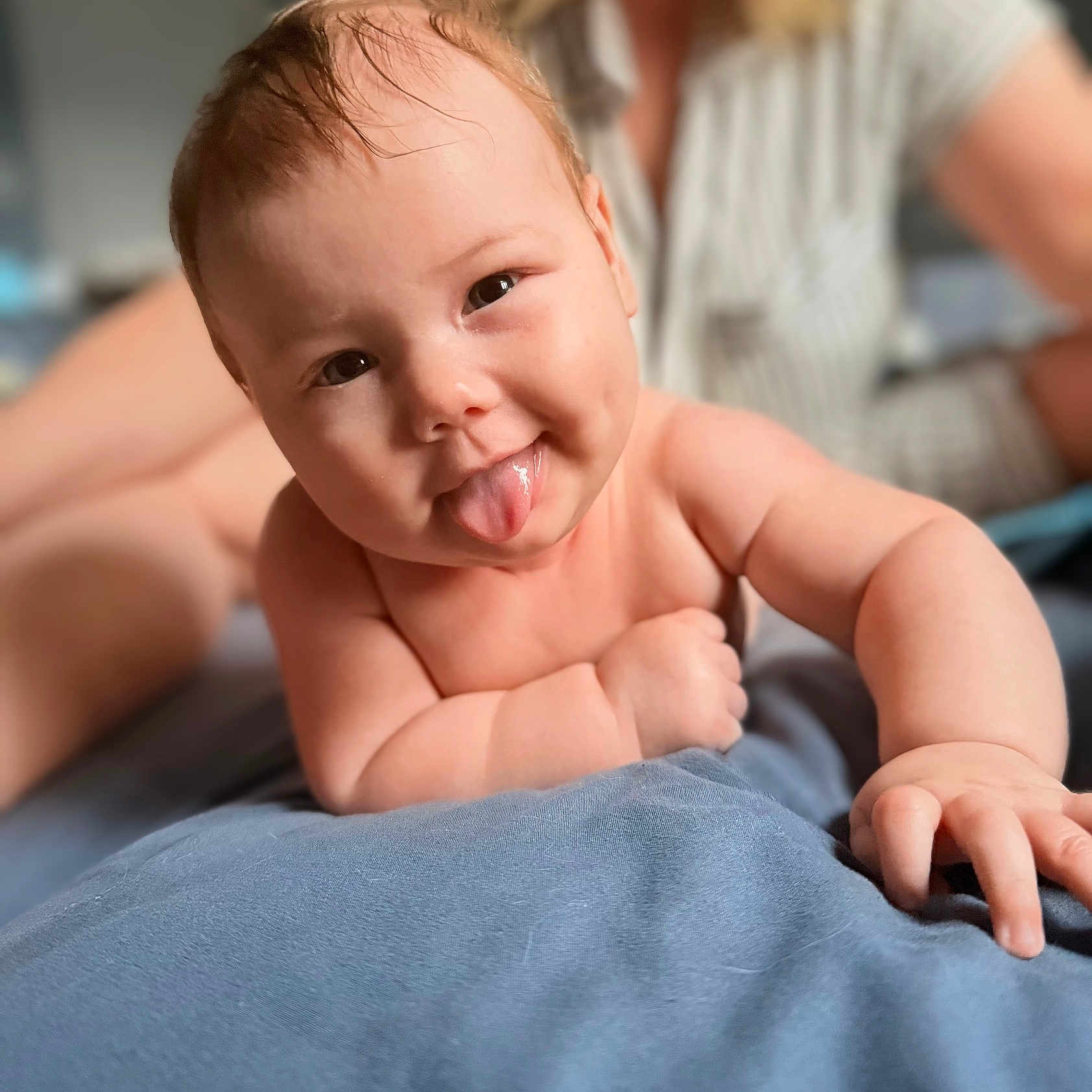 Anne joined the competition — help win amazing prizes! adult, arm, baby, bed, blanket, blurred_background, child, closeup, cute, expression, hand, happy, indoors, infant, person, playful, portrait, skin, smiling, tongue