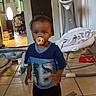 baby, baby_chair, baby_equipment, blanket, blue_shirt, casual_clothing, child, curly_hair, cute, door, floor, furniture, home, indoor, living_room, pacifier, person, tile_floor, toddler, toy