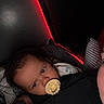Julian joined the competition — help win amazing prizes! baby, pacifier, sleepy, person, pillow, blanket, tattoo, arm, dim_light, red_light, indoor, closeup, face, head, comfort, rest, portrait, dark_background, cuddle, infant