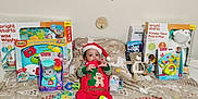 Jaylen is registered to the contest to win money with this photo: baby, banner, blanket, child, christmas, colorful, festive, fisher_price, gift_boxes, holiday, holiday_decor, indoor, plush_toy, red_outfit, santa_hat, smiling, striped_socks, toys, vtech, wooden_plaque