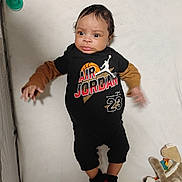 Jaylen is registered to the contest to win money with this photo: air_jordan, baby, blanket, child, clothing, colorful, crib, cute, expression, face, footwear, indoor, infant, lying_down, person, playtime, socks, stuffed_animal, toys, young_child