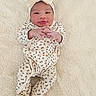 baby, infant, bow, headband, leopard_print, onesie, clothing, blanket, soft_texture, cute, child, portrait, smiling, hands, footed_pajamas, lying_down, indoor, newborn, skin, face
