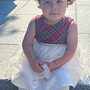 Angela Ademi joined the competition — help win amazing prizes! toddler, child, dress, plaid, white_tulle, curly_hair, sitting, outdoor, stone_steps, sunlight, shadow, serious_face, shoes, socks, person, portrait, daylight, young_child, casual, fashion