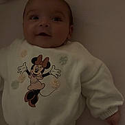 Ceylan participe au concours pour gagner de l'argent avec cette photo : child, baby, infant, smiling, lying_down, onesie, minnie_mouse, cartoon_character, plush_toy, stuffed_animal, crib, mattress, pajamas, clothing, portrait, cute, adorable, face, hand, soft_lighting
