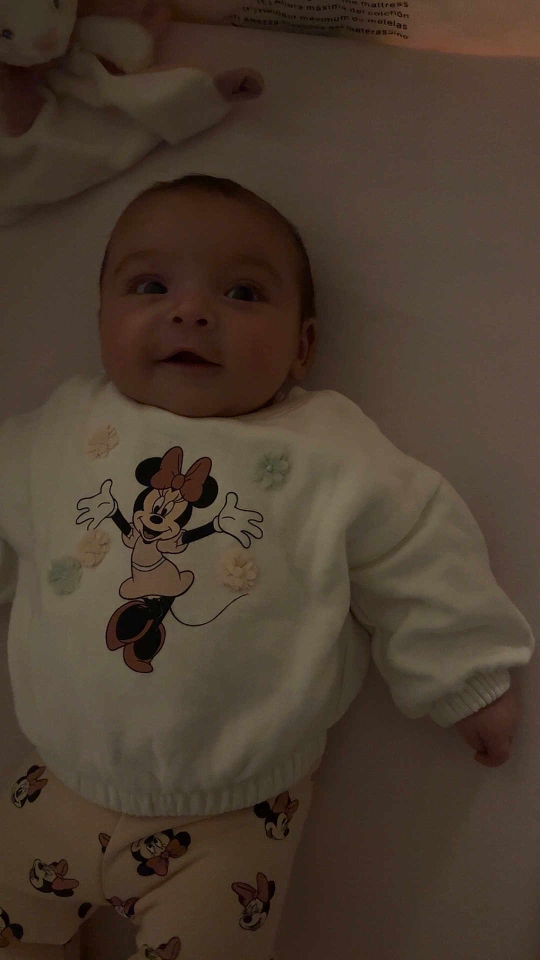 Ceylan participe au concours pour gagner de l'argent avec cette photo : child, baby, infant, smiling, lying_down, onesie, minnie_mouse, cartoon_character, plush_toy, stuffed_animal, crib, mattress, pajamas, clothing, portrait, cute, adorable, face, hand, soft_lighting