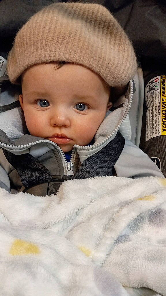 Jaxson joined the competition — help win amazing prizes! baby, baby_toddler_clothing, beanie, cap, cheek, child, comfort, eye, fashion_accessory, fur, headwear, hood, knit_cap, outerwear, person, sitting, skin, sleeve, toddler, winter