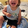 toddler, child, laughing, smiling, cap, tank_top, bed, blanket, indoors, happy, person, clothing, furniture, room, toy_car, decor, casual, cute, skin, hair