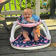 Breyer joined the competition — help win amazing prizes! baby, walker, toy, outdoor, porch, wooden_floor, greenery, sunlight, smiling, cheerful, child, infant, plush_toy, clothing, seat, playtime, nature, fence, happy, cute