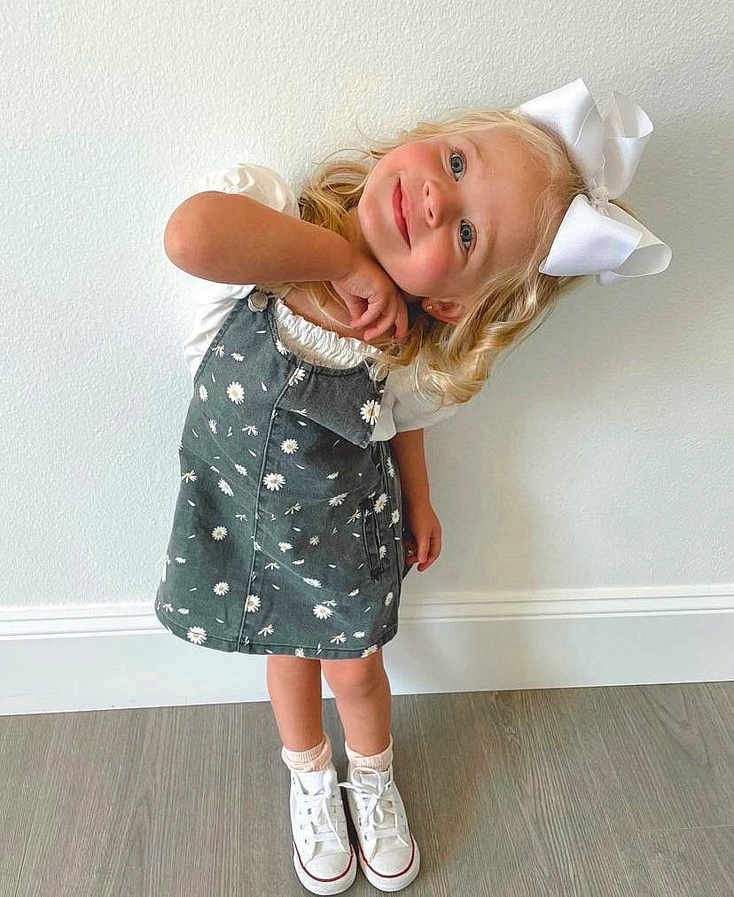 Posie participe au concours pour gagner de l'argent avec cette photo : baby_toddler_clothing, dress, elbow, face, flash_photography, flooring, footwear, gesture, happy, human_leg, jeans, joy, knee, leg, person, sandal, shoe, sleeve, smile, sock