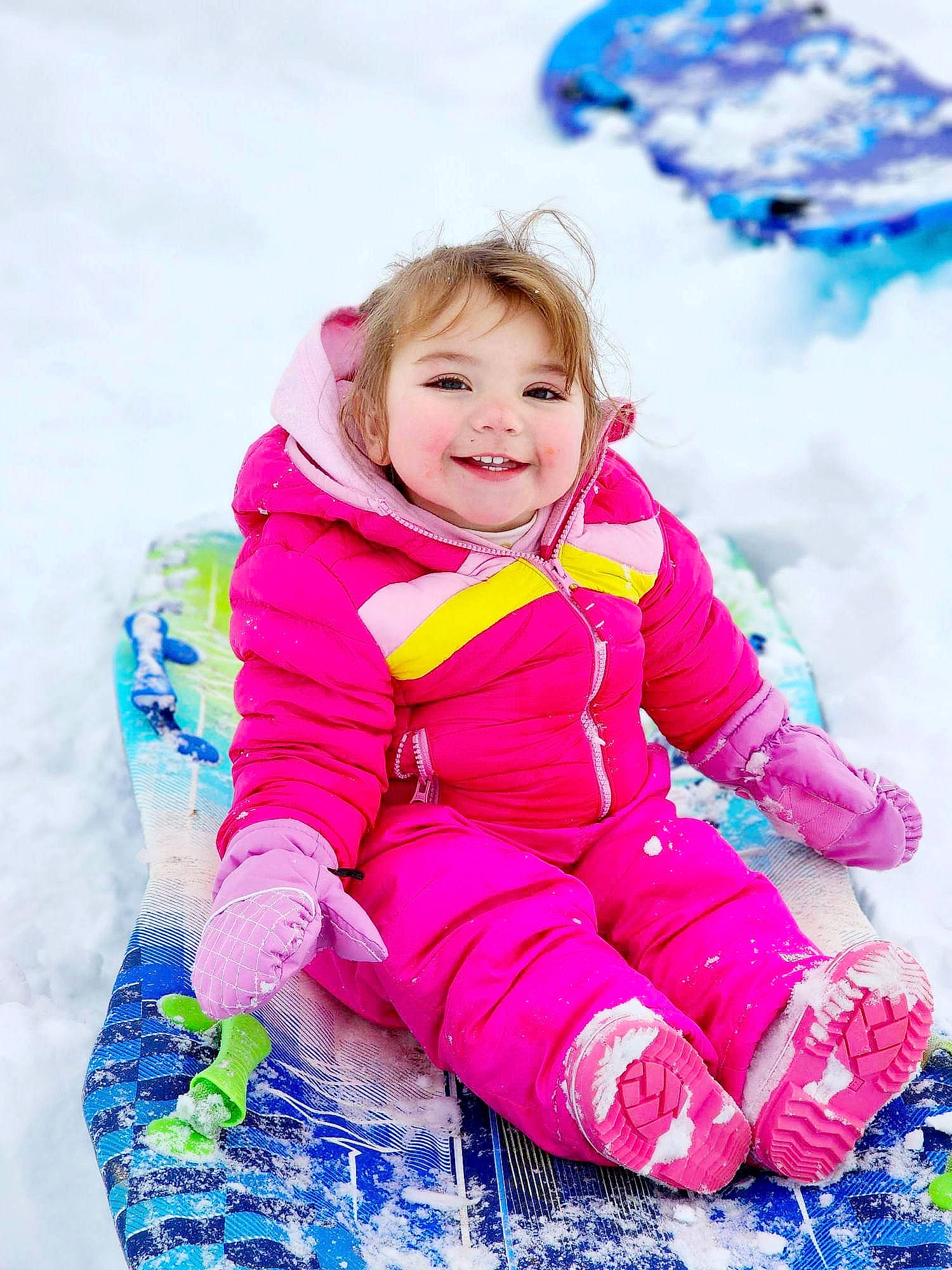 Gunner is registered to the contest to win money with this photo: baby_toddler_clothing, blue, child, electric_blue, fun, happy, human_body, jacket, joy, leisure, magenta, people_in_nature, person, pink, playing_with_kids, purple, recreation, sleeve, smile, snow