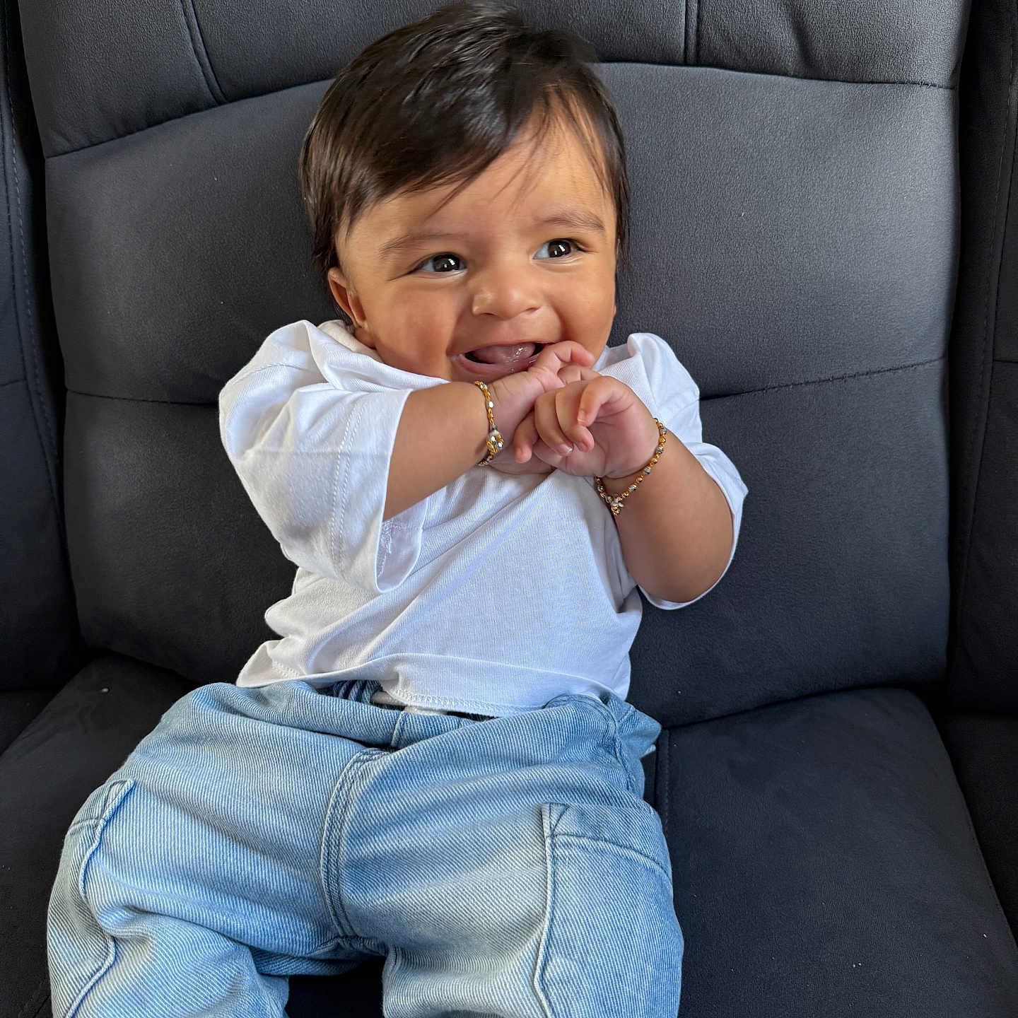 Viransh Patel is registered to the contest to win money with this photo: baby, black_hair, bracelets, casual_clothing, cheerful, child, closeup, cushioned_chair, cute, denim_jeans, happy, human, indoor, infant, playful, portrait, sitting, smiling, white_shirt, young_child