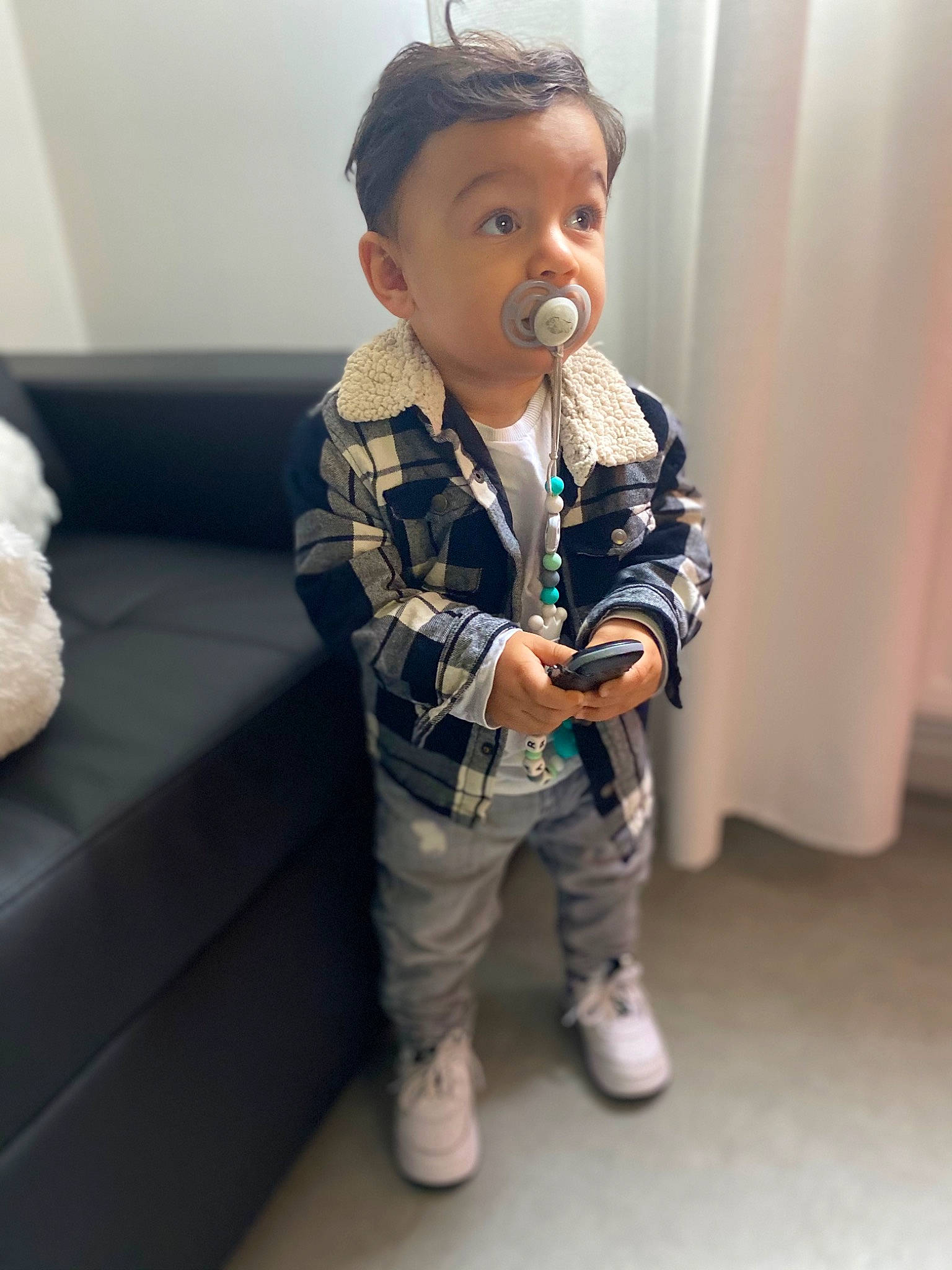 Marwan participe au concours pour gagner de l'argent avec cette photo : baby, baby_toddler_clothing, child, couch, curtain, face, fur, living_room, person, pillow, sock, sofa_bed, stuffed_toy, teddy_bear, toddler