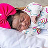 Naomi joined the competition — help win amazing prizes! newborn, baby, sleeping, pink_bow, onesie, rainbow_pattern, cloud_pattern, pillow, basket, infant, cute, resting, soft, cozy, indoor, closeup, portrait, child, peaceful, adorable