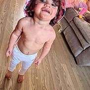 Nadiyah Claire joined the competition — help win amazing prizes! toddler, child, barefoot, smiling, hat, messy_face, indoor, wooden_floor, pants, living_room, couch, person, toy, footwear, relaxed, happy, casual, home, playful, young_child
