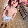 barefoot, casual, child, couch, footwear, happy, hat, home, indoor, living_room, messy_face, pants, person, playful, relaxed, smiling, toddler, toy, wooden_floor, young_child