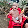 baby, child, diaper, red_chair, smile, happy, outdoor, person, arm, garden, plant, window, house, daylight, skin, cute, sitting, holding, adult, nature
