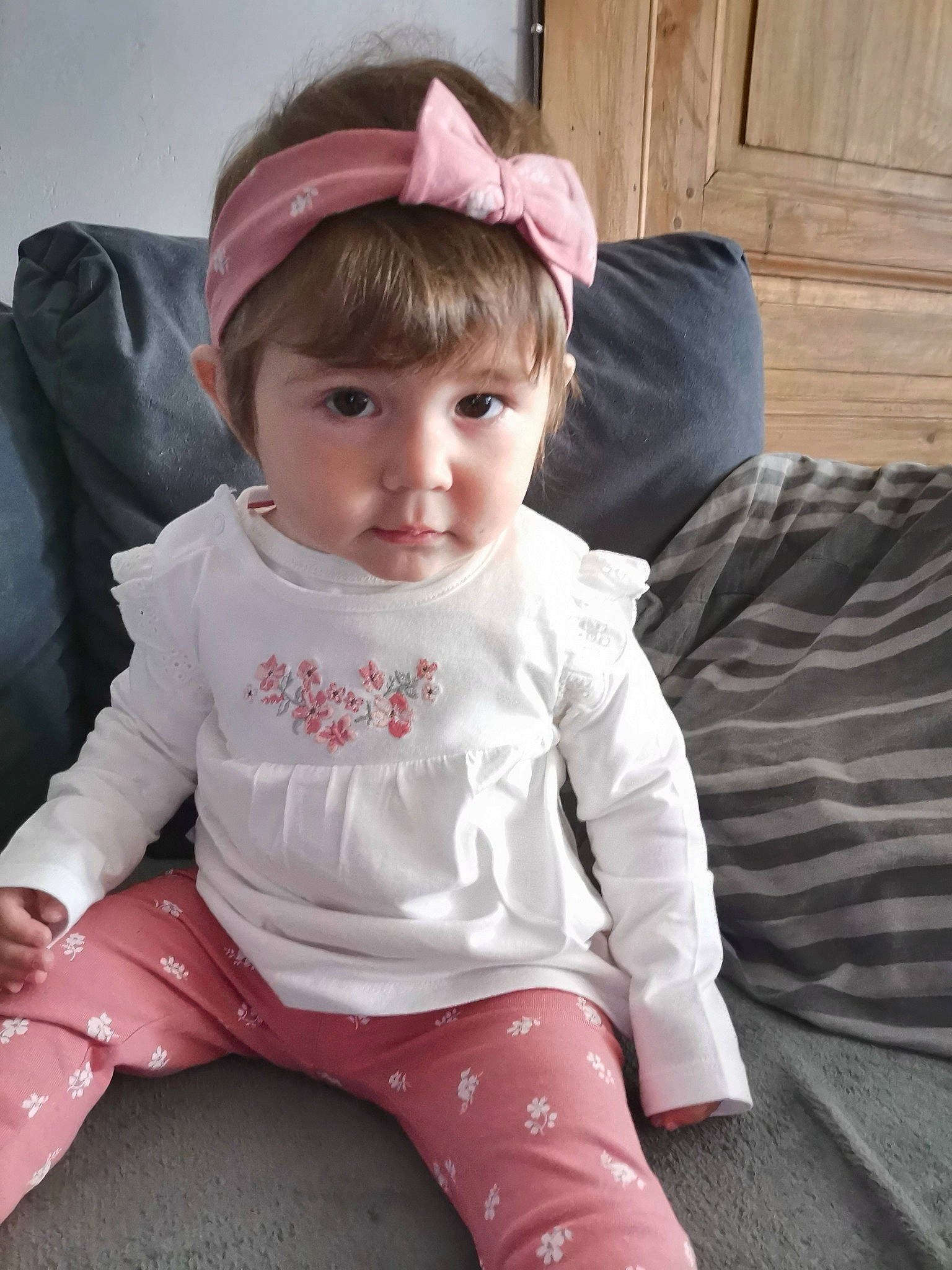 Mina a rejoint le concours — aidez-le/la à gagner de superbes lots ! baby, baby_toddler_clothing, cap, cheek, child, comfort, cool, door, fashion_accessory, happy, knee, lap, lip, magenta, person, pink, sitting, skin, sleeve, t_shirt