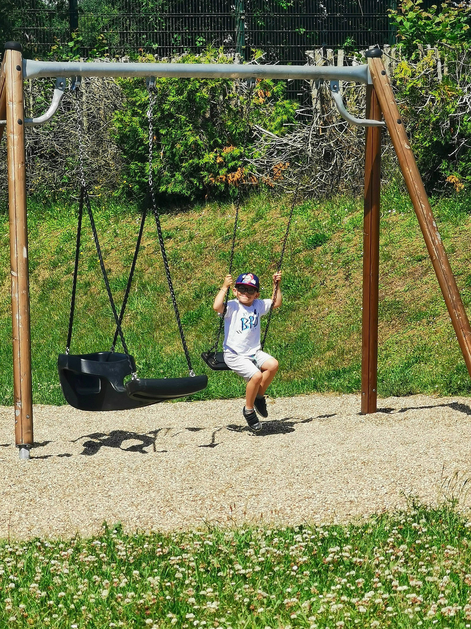Adriano participe au concours pour gagner de l'argent avec cette photo : city, fun, garden, grass, green, hat, headwear, landscape, leisure, mesh, net, outdoor_play_equipment, people_in_nature, person, plant, play, playground, recreation, soil, swing