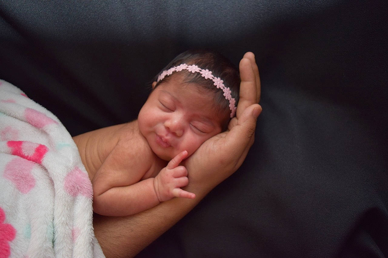 Krisha is registered to the contest to win money with this photo: arm, baby, birth, cheek, child, face, finger, gesture, hair_accessory, hand, head, headband, headgear, person, photograph, photography, pink, skin, sleep, thumb