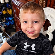Braxton joined the competition — help win amazing prizes! child, toddler, boy, portrait, smiling, happy, indoors, seated, chair, ornate_furniture, black_shirt, sportswear, under_armour, short_hair, blue_eyes, teeth, shoe_collection, wooden_furniture, home, close_up