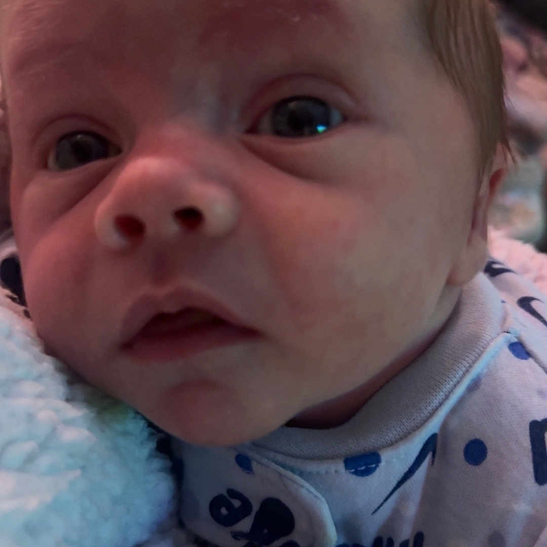 Lucenzo a rejoint le concours — aidez-le/la à gagner de superbes lots ! baby, blanket, blue, child, closeup, cute, expression, face, hand, indoor, infant, newborn, onesie, person, portrait, skin, sleepwear, soft, white, young